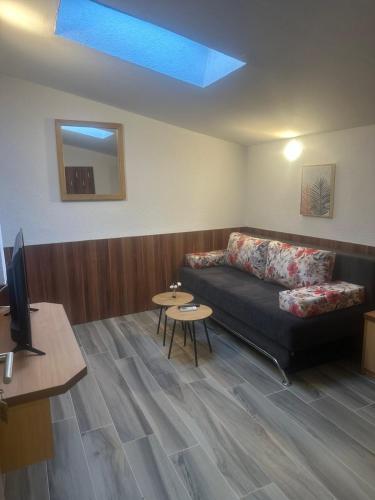 a living room with a couch and a tv at Hotel Piramida Sunca in Visoko