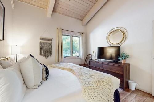 a bedroom with a bed and a mirror and a television at Snowmas Village A4 in Snowmass Village