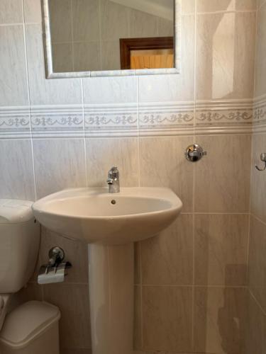 a bathroom with a sink and a toilet and a mirror at Casa da vala in Praia de Mira