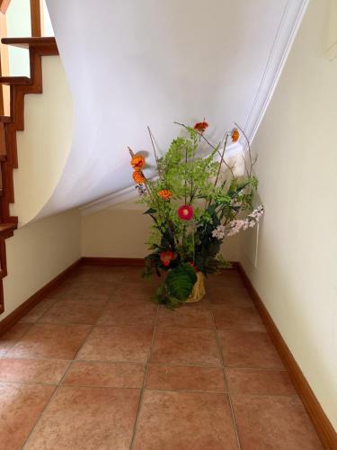 a vase of flowers sitting on the floor in a room at Casa da vala in Praia de Mira