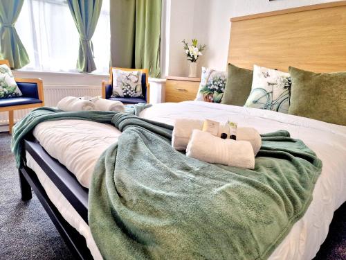 a bed with two stuffed animals on top of it at Sweet Rose Guest House Room 6 in Oxford