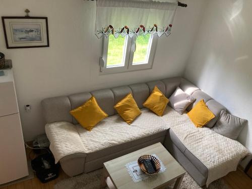 a living room with a couch with yellow pillows at Seoski raj in Andrijevica