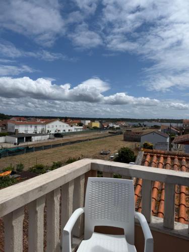 a white chair sitting on a balcony with a view at Casa da vala in Praia de Mira