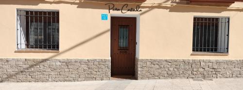 a building with a brown door and two windows at Apartamento Peña Cortada in Alhama de Aragón