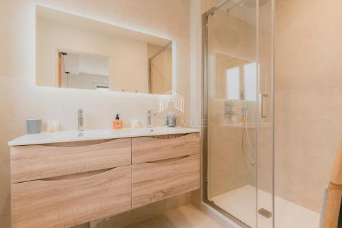 une salle de bain avec un lavabo et une douche dans l'établissement Les Prairies de Deauville Plein centre CLS, à Deauville