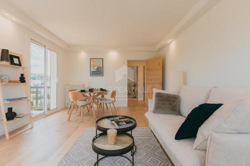 un salon avec un canapé blanc et une table dans l'établissement Les Prairies de Deauville Plein centre CLS, à Deauville