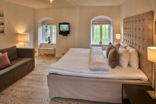 a bedroom with a large bed and a couch at Holckenhavn Slot in Nyborg