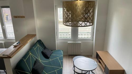 une chambre avec un canapé, une table et une fenêtre dans l'établissement maison de ville, à Saint-Pierre-de-Plesguen