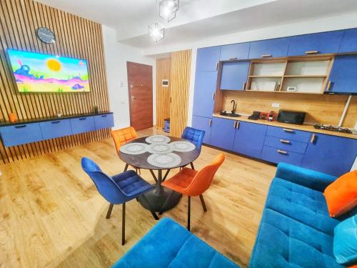 a living room with a table and blue chairs at Alpin Confort Predeal in Predeal