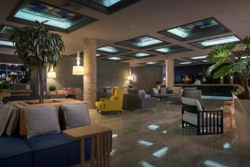 a hotel lobby with a blue couch and chairs at Porto Angeli in Archangelos
