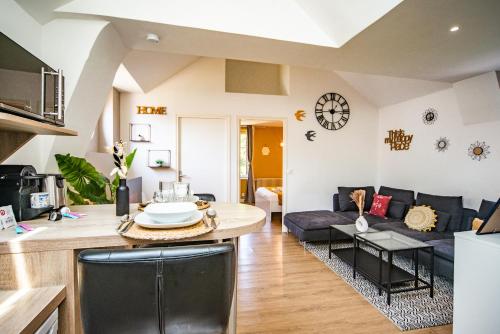 une cuisine et un salon avec un canapé et une table dans l'établissement Le Ballanais - Parking - Netflix, à Ballan-Miré