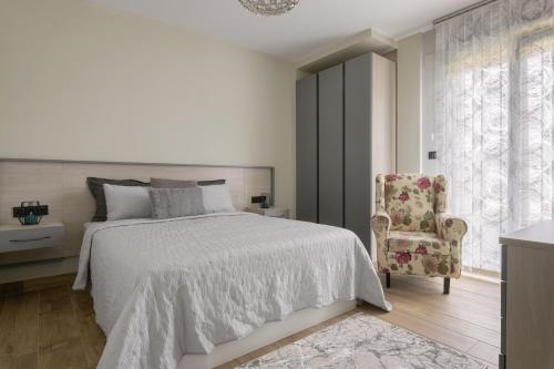 a white bedroom with a bed and a chair at Casa con Vistas al Paisaje y Encanto en el Corazón del País Vasco,España in Mungia