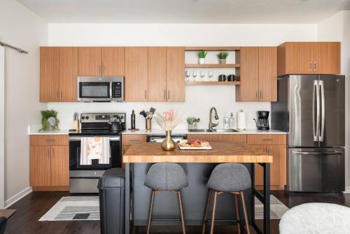 a kitchen with a wooden table with two bar stools at TC Sweet Pea - 2-Bedroom Condo Near Downtown TC! in Traverse City