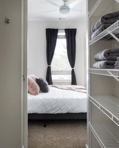 a bedroom with a bed and a window at TC Sweet Pea - 2-Bedroom Condo Near Downtown TC! in Traverse City