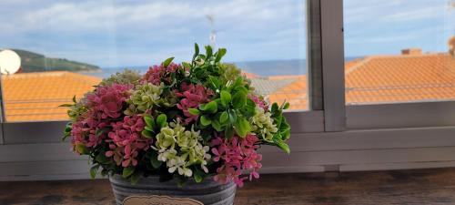 un ramo de flores en un jarrón delante de una ventana en Arribolas, en Bermeo