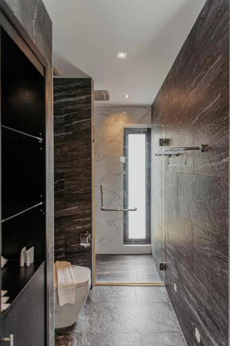 a bathroom with a toilet and a glass shower at Tropical Haven Villa 4-Bedroom Private Pool Butler Choeng Thale Phuket in Bang Tao Beach