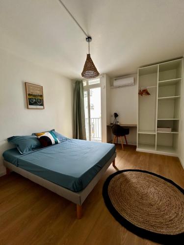 a bedroom with a bed with a blue comforter and a rug at Confort et proximité à Pointe-à-Pitre, logement spacieux pour 4-6 personnes in Pointe-à-Pitre