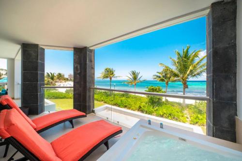 a room with a view of the ocean at Beachfront Condo with tub, 3 BR & Pool - At Mareazul Condo Corazon in Playa del Carmen