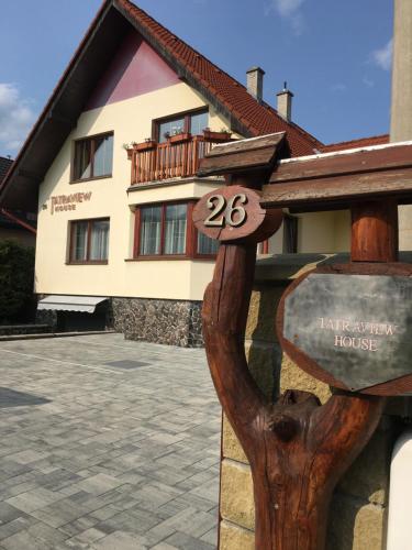 a building with a sign in front of it at Tatraview House in Veľká Lomnica
