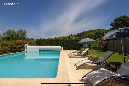 加尔加斯appartement avec piscine的配有椅子和遮阳伞的游泳池