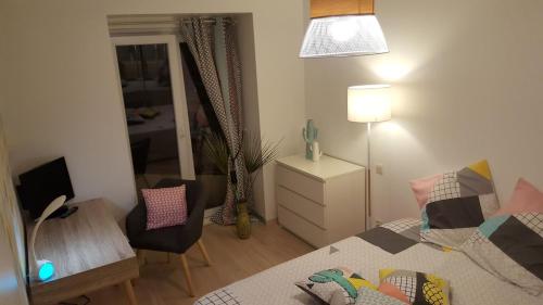 une chambre avec un lit, un bureau et une chaise dans l'établissement Apartment with large terrace, ground floor, à Narbonne