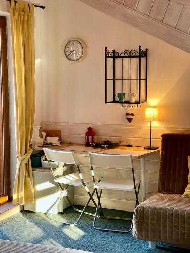 a room with a table and chairs and a clock at Willa Avita in Karpacz