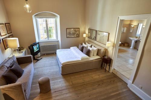 a bedroom with a bed and a couch and a mirror at Holckenhavn Slot in Nyborg