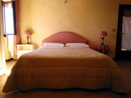 a bedroom with a large bed with two lamps at Casa Patrizia in Acquaviva Picena