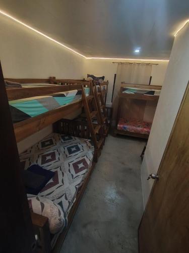 a room with three bunk beds and a door at Backpackers homebase El Nido Palawan Free use of motorbike in El Nido
