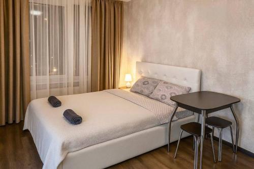 a bedroom with a white bed and a table at Best location in Crăsnăşeni