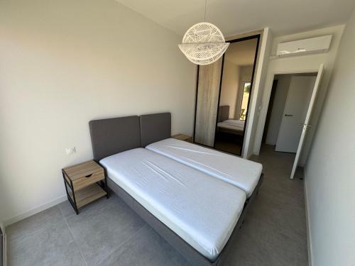 een slaapkamer met een bed, een tafel en een spiegel bij Bord de mer exceptionnel in Marseillan