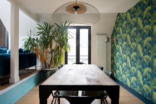 une salle à manger avec une table en bois et des plantes dans l'établissement Loft pour 2 au port de Caen, à Caen