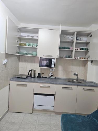 a small kitchen with white cabinets and a sink at Apartmani Sabotic in Sutomore