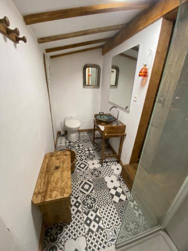une salle de bain avec toilettes et table sur un sol carrelé dans l'établissement Gîte en Pays Basque Les Chênes Avec jacuzzi, à Came