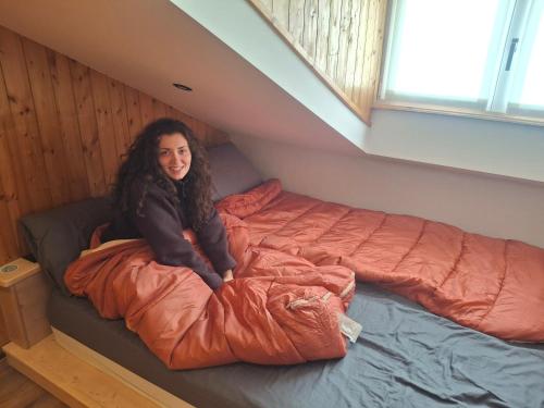 a girl sitting on a large bed in a room at Inner Holiday Dolomites 5 in Dimaro