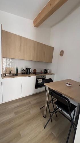 Il comprend une cuisine avec une table en bois et du parquet. dans l'établissement L'Annexe Marseille, à Marseille