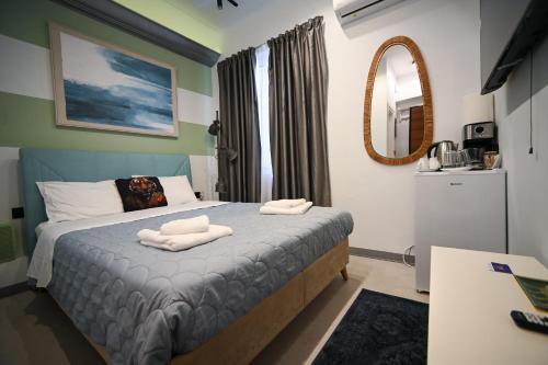 a bedroom with a bed with two towels on it at Hermes Suite Klathmonos by Zeussuites in Athens