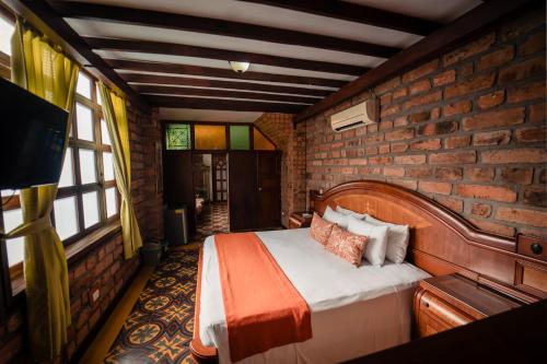 a bedroom with a bed in a brick wall at Hotel Plaza Menor in Santa Fe de Antioquia