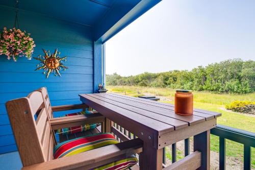 a wooden table and chairs on the porch of a house at Ocean Shores Condo with Balcony Less Than 1 Mi to Beach! in Ocean Shores