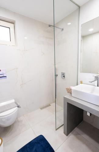 a white bathroom with a sink and a toilet at Nautilus house in Stalos