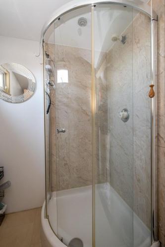 a shower with a glass door in a bathroom at Shore View, Aldeburgh - A lovely Seafront House on famous Crag Path with uninterrupted Beach Views - Aldeburgh Coastal Cottages in Aldeburgh