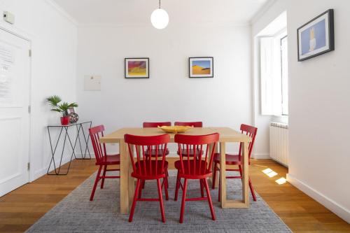a dining room with a table and red chairs at LV Premier Bica River View in Lisbon