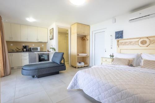 a bedroom with a large bed and a blue chair at Nautilus house in Stalos