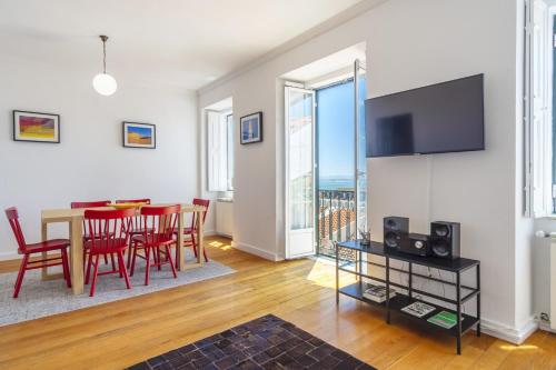 a living room with a table and chairs and a television at LV Premier Bica River View in Lisbon