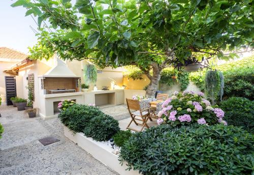 a garden with a table and chairs and flowers at Nautilus house in Stalos