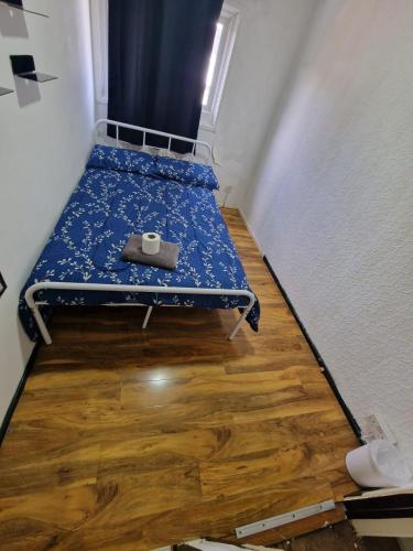 a small bed in a room with a wooden floor at Cosy Beds & Rooms in London