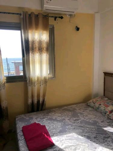 una camera da letto con un letto e una finestra con tende di Monsoleil a Luanda