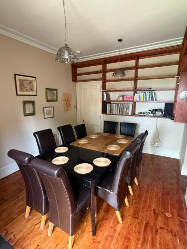 a dining room with a table and leather chairs at The Old Manse Oyne in Oyne