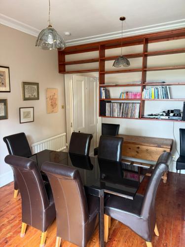 a dining room with a table and leather chairs at The Old Manse Oyne in Oyne