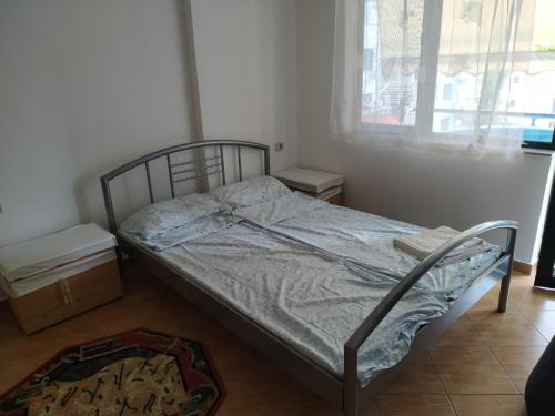 1 cama no hecha en una habitación con ventana en Flori Apartment, en Golem